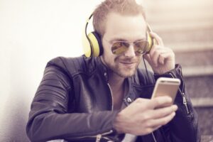 junger Mann mit Kopfhörer und Smartphone